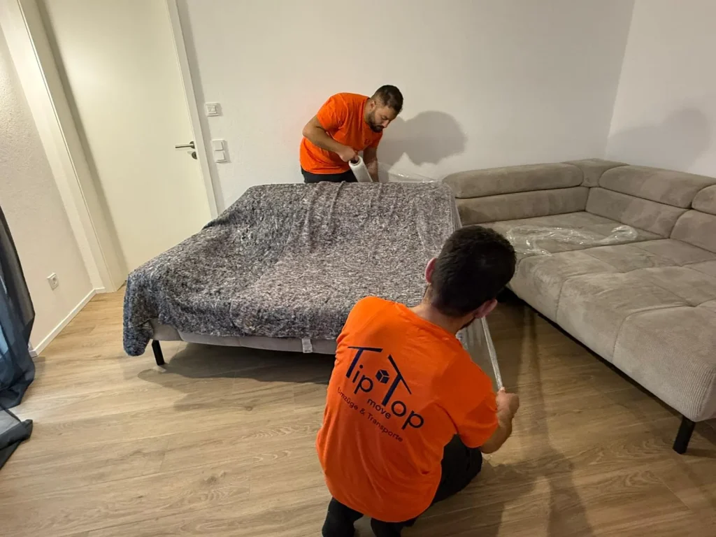 Umzugshelfer von TipTop Move decken Möbel beim Seniorenumzug in Konstanz sorgfältig ab